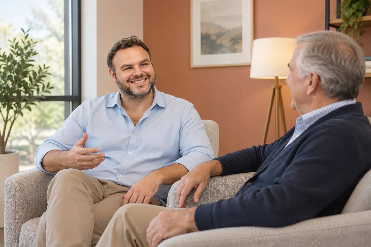 Illustrative scene: George Adjian discussing wellness and recovery with an adult patient in lounge chairs